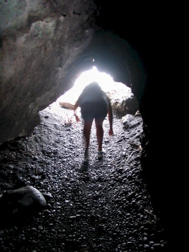 A short tunnel in the lava rock where the ocean crashes in.  Location is Waianapanapa Black Sand Beach
