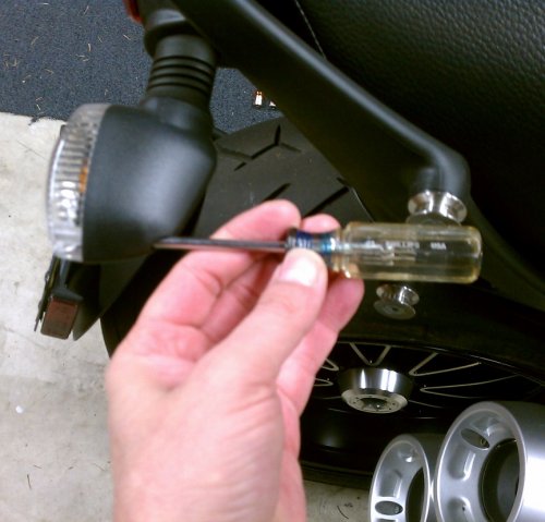 Use a #1 Phillips screwdriver to remove the clear lens retaining screw.
