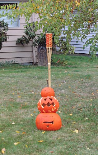 Pumpkin totem pole held up with a tiki torch...
