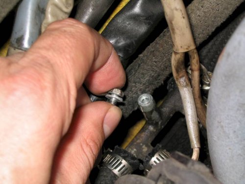 Use a 7mm socket to remove the bolt.  If the engine was just running becareful of fuel squirting out!
